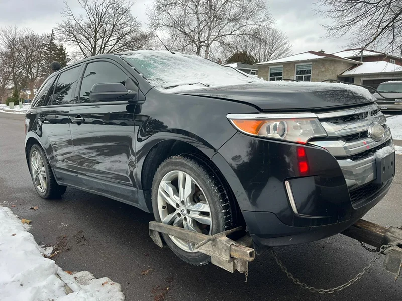 Black SUV loaded onto a tow truck for junk and scrap car towing in Barrie, Ontario